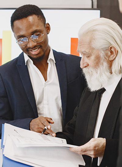 African man in a black suit. International partners. Young guys with senior man.